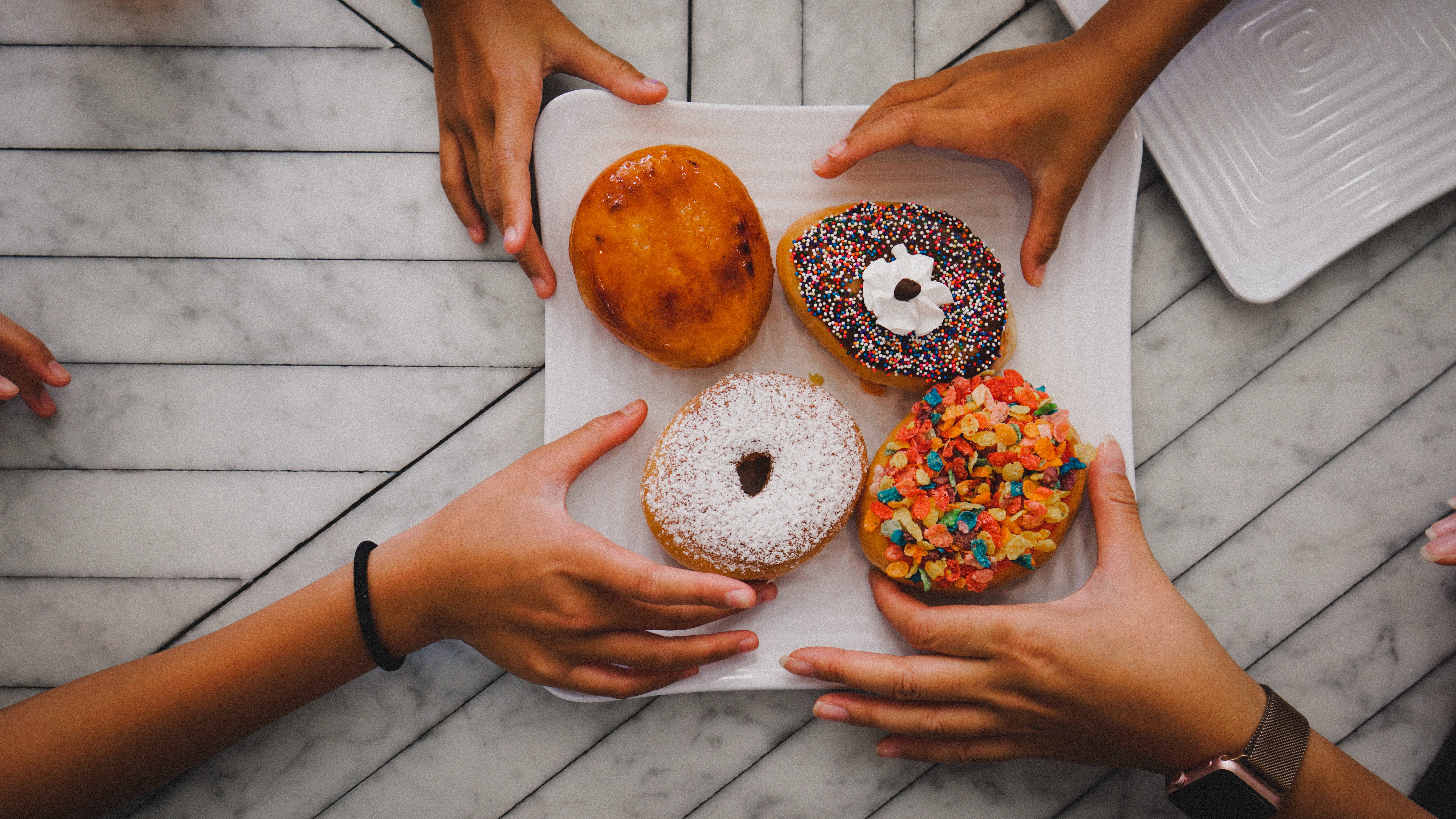 four-people-sharing-donuts
